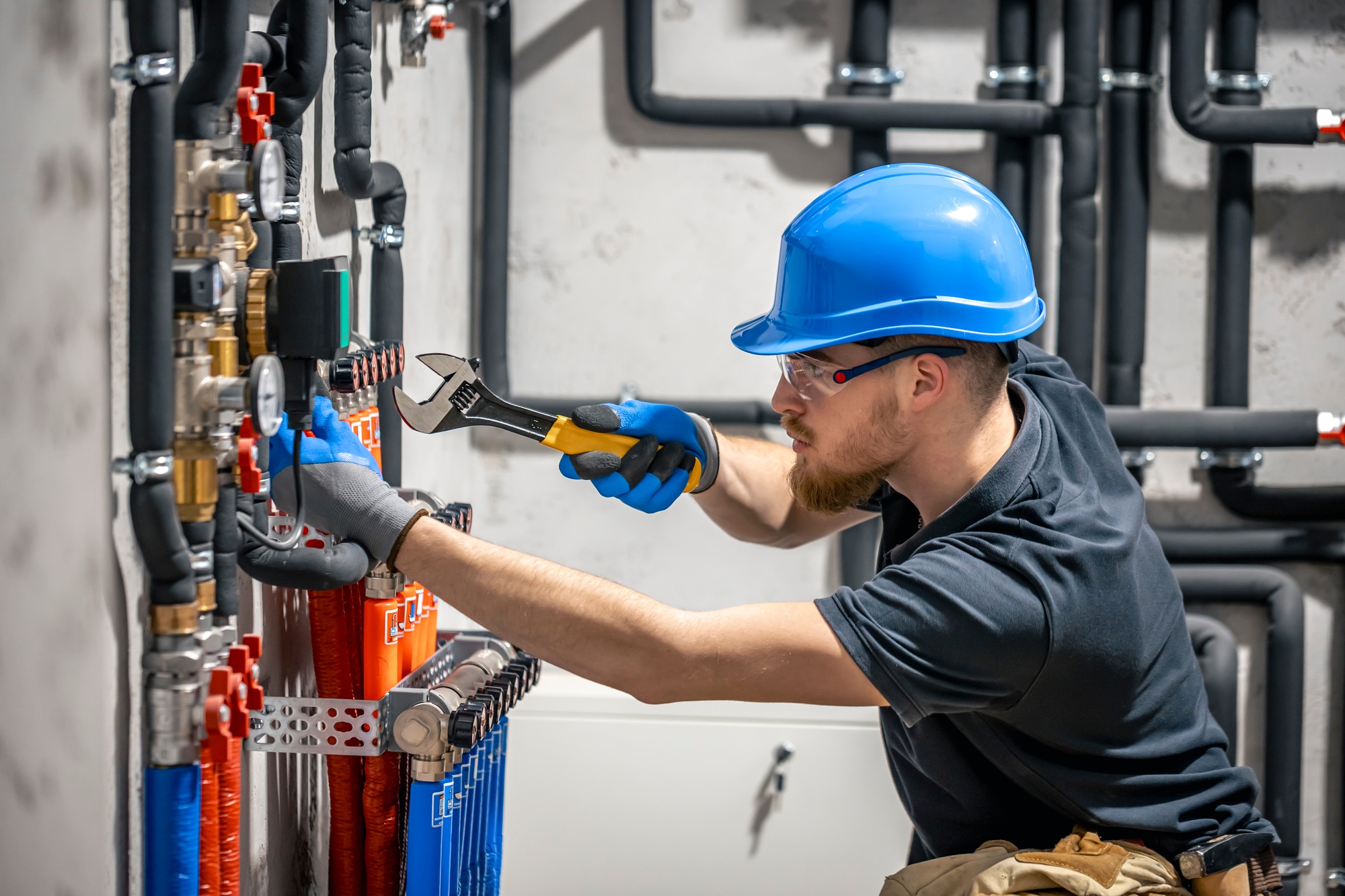 The technician checking the heating system in the boiler room.